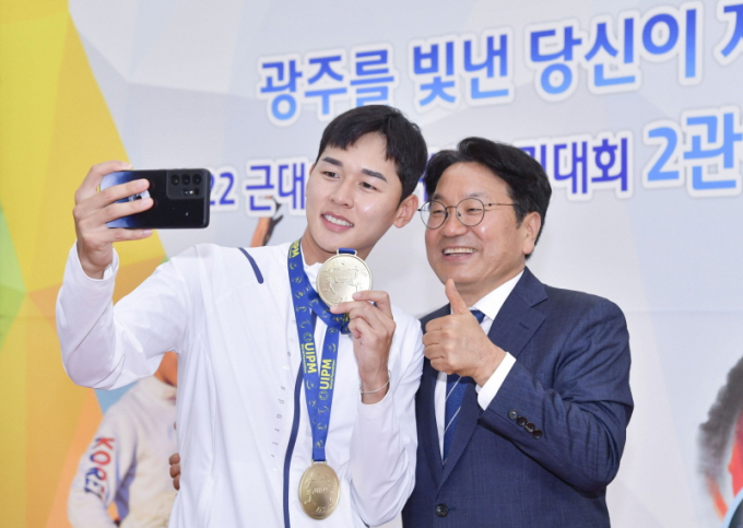 강기정 광주광역시장(오른쪽)이 지난 2022년 8월 8일 시청 시민홀에서 열린 ‘2022 근대5종 세계선수권대회 2관왕 전웅태 선수 환영식’에 참석해 전웅태 선수와 셀카를 촬영하고 있다./사진=광주시