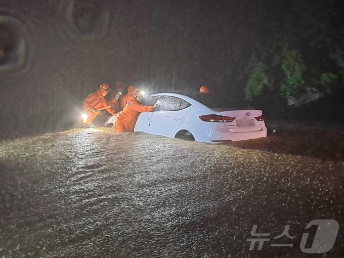 23일 강원 내륙을 중심으로 호우특보가 내려진 가운데 밤사이 강원 철원군 갈말읍 내대리의 한 도로에 차량이 침수돼 소방대원들이 차량을 이동시키고 있다. (강원도소방본부 제공) 2024.7.23/뉴스1 ⓒ News1 윤왕근 기자