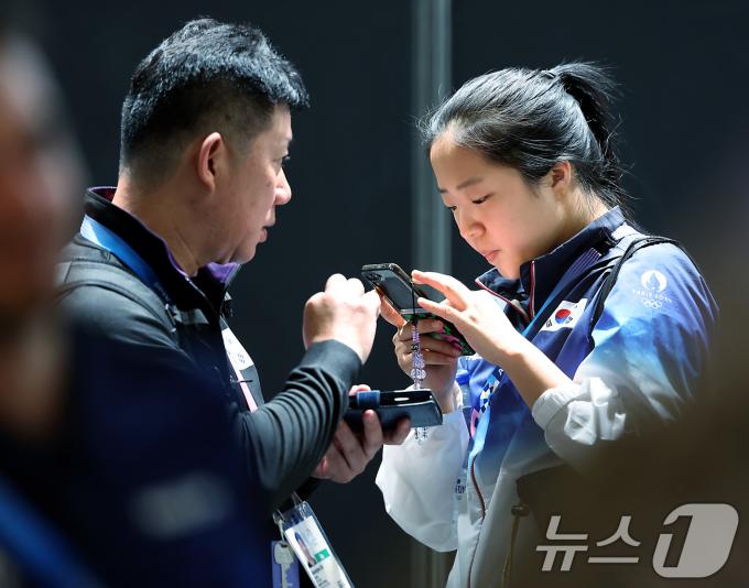 대한민국 탁구대표팀 신유빈 선수가 25일 오전(한국시간) 프랑스 파리 사우스 파리 아레나4 기자회견장 밖에서 대진이 완성된 뒤 팀 관계자와 대화를 나누고 있다. 2024.7.25/뉴스1 ⓒ News1 박정호 기자