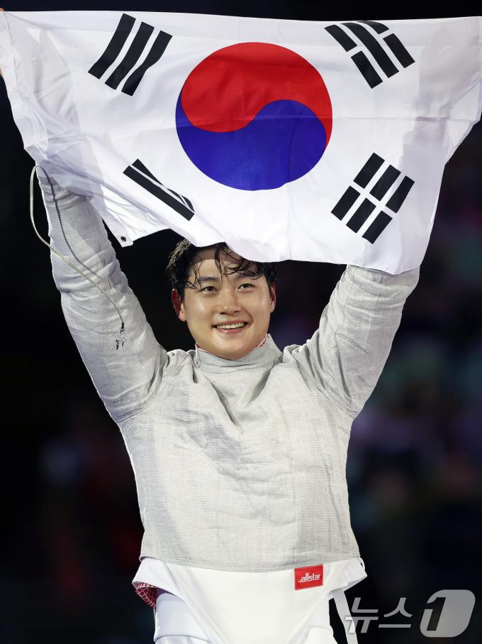 대한민국 펜싱 대표팀 오상욱 선수가 28일(한국시간) 프랑스 파리 그랑 팔레에서 열린 2024 파리올림픽 남자 사브르 개인 튀니지 파레스 페르자니 선수와의 경기에서 금메달을 차지한 후 태극기를 들어보이고 있다. 2024.7.28/뉴스1 ⓒ News1 박정호 기자