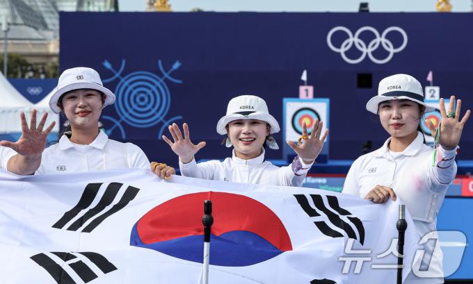 대한민국 양궁대표팀 임시현, 남수현, 전훈영이 29일(한국시간) 프랑스 파리 레쟁발리드 특설 사로에서 열린 2024 파리올림픽 양궁 여자 단체전 중국과의 결승전에서 금메달을 획득한 후 태극기를 들어보이고 있다. 2024.7.29/뉴스1 ⓒ News1 이동해 기자