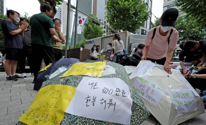 티몬과 위메프의 정산·환불 지연 사태가 지속되고 있는 28일 오후 서울 강남구 큐텐 본사 앞에서 피해자들이 사태 해결을 촉구하는 문구를 우산에 붙이며 시위를 준비하고 있다./사진=뉴스1