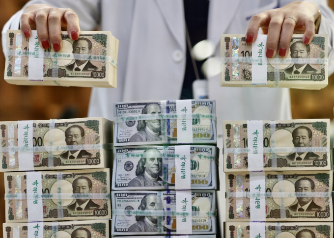  엔화 강세 흐름이 이어지고 있는 26일 오전 서울 중구 하나은행 위변조대응센터에서 관계자가 엔화와 달러를 정리하고 있다./사진-뉴시스