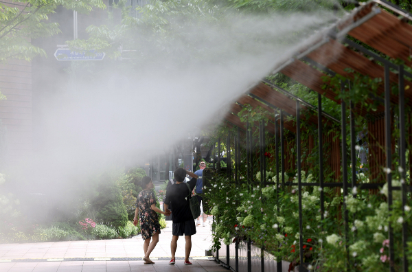 30일 전국이 가끔 구름이 많은 가운데 더운 날씨가 예상되며 열대야 현상이 나타나겠다. 사진은 지난 24일 서울 중구 서울시청 앞에서 행인들이 더위를 피해 쿨링포그 아래로 지나가는 모습. /사진=뉴시스 