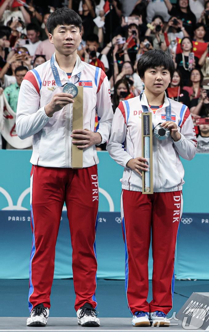 [사진] 은메달 들어보이는 北 리종식·김금용