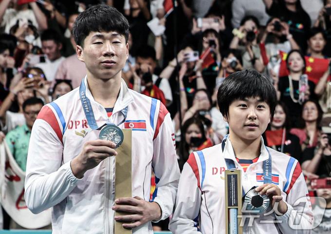 [사진] 은메달 들어보이는 北 리종식·김금용