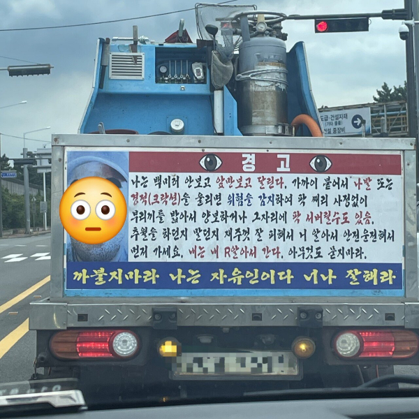 전남 광양시 도로 위 한 운전자가 뒷 차량을 위협하는 경고문을 달고 다니는 화물 트럭 사진을 공유해 화제다. 사진은 도로 위 해당 경고문을 부착한 채 운행하는 차량. /사진=에펨코리아 캡처.