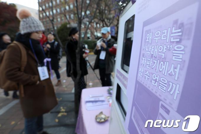 19일 오후 서울 중구 정동길에 페미니즘 활동 단체 페미당당이 '낙태죄' 폐지를 주장하며 모형 미프진(유산 유도제) 자판기를 설치해 약물적 임신중단법을 소개하고 있다.  2017.11.19/뉴스1 ⓒ News1 민경석 기자