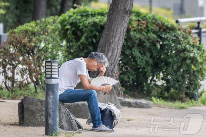 지난 26일 일본 도쿄에 있는 오다이바 해변 공원에서 한 남성이 부채로 더위를 쫓고 있다. 2024.07.26. ⓒ AFP=뉴스1 ⓒ News1 김종훈 기자