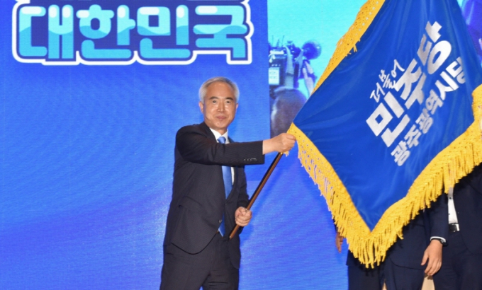 4일 더불어민주당 광주시당위원장에 당선된 양부남 국회의원이 광주시당 당기를 흔들고 있다./사진=민주당 광주시당