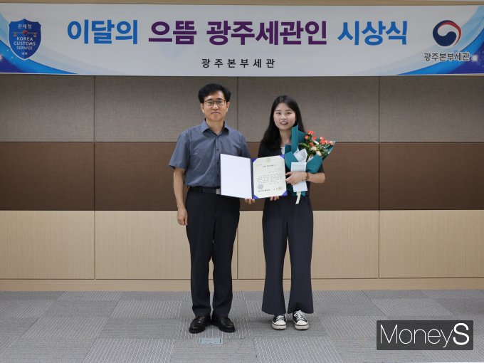 김동수 광주본부세관장(왼쪽)이 박진경 광주본부세관 주무관에게 8월 '으뜸 광주세관인' 포상을  하고 기념촬영을 하고 있다/사진=광주본부세관 제공.