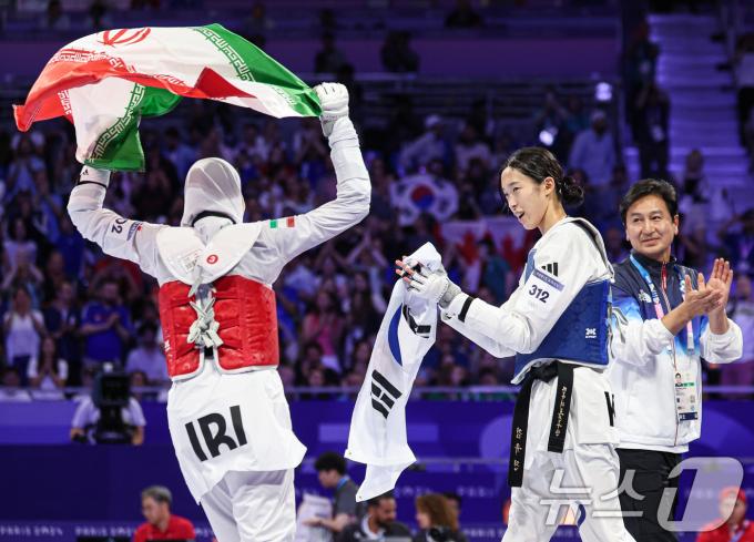 대한민국 태권도 국가대표팀 김유진 선수가 9일(한국시간) 프랑스 파리 그랑 팔레에서 진행된 2024 파리올림픽 태권도 여자 57kg급 결승 경기 이란의 나히드 키야니찬데 선수와의 경기에서 은메달을 확정지은 나히드 키야니찬데가 국기를 들고 흔들자 박수를 치고 있다. 2024.8.9/뉴스1 ⓒ News1 이동해 기자