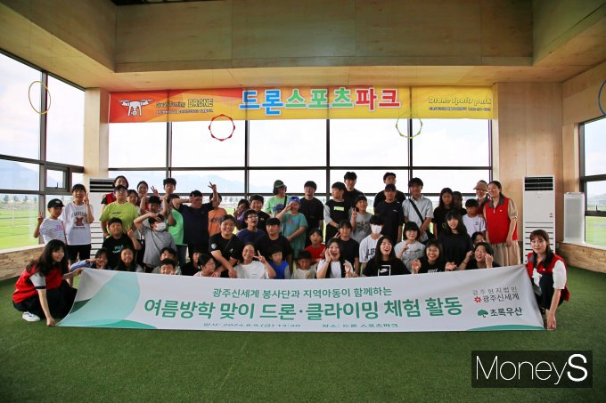 광주신세계 봉사단이 지난 9일 드론스포츠파크에서 드론과 클라이밍 체험 활동에 나선 지역 아동들과 기념사진을 촬영하고 있다/사진=광주신세계 제공.