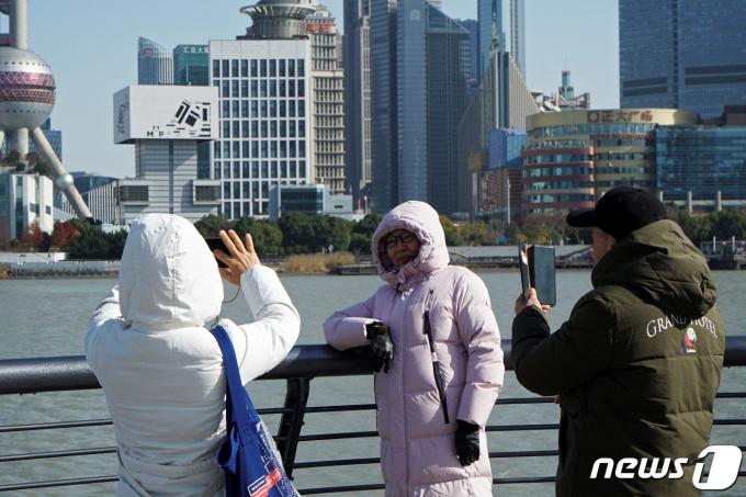 21일 중국 상하이에 맹추위가 찾아오자 행인들이 두꺼운 패딩 재킷을 입고 돌아다니고 있다. 2023.12.21 ⓒ 로이터=뉴스1 ⓒ News1 강민경 기자