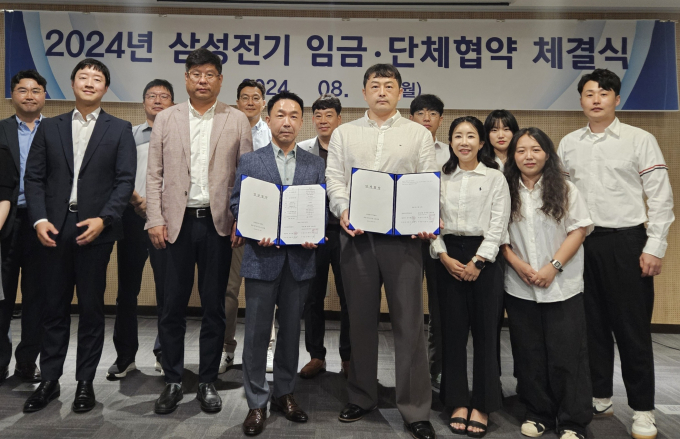 지난 12일 삼성전기 '2024년 임금협약 체결식'에 참석한 박봉수 피플팀장(부사장, 앞줄 왼쪽 세번째)와 신훈식 존중노종조합지부장(앞줄 왼쪽 네번째)가 기념사진을 촬영하고 있다. / 사진=삼성전기