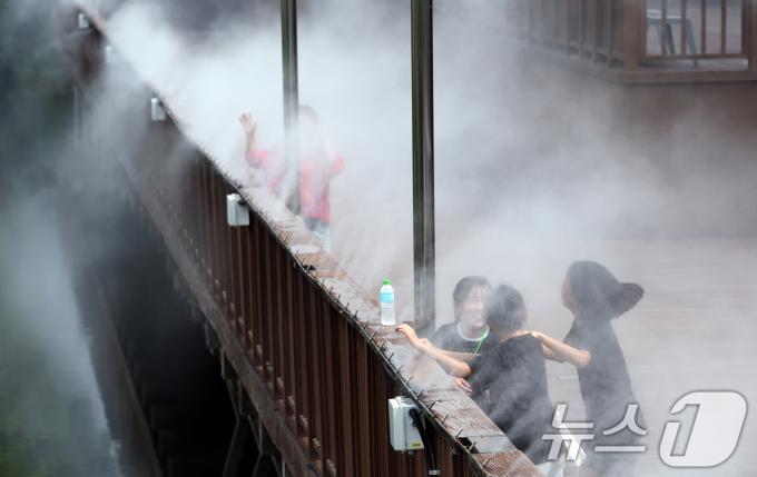 폭염경보가 발효된 지난 12일 광주 남구 노대동 물빛근린공원 쿨링포그 밑에서 학생들이 더위를 식히고 있다. 뉴스1 ⓒ News1 김태성 기자