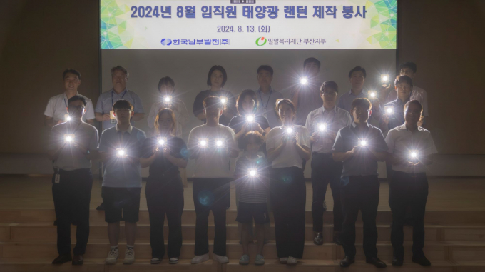 한국남부발전 임직원들이 13일 본사 강당에서 방학을 맞은 자녀들과 함께 에너지 빈곤국가에 기증할 태양광 랜턴을 제작 후 기념촬영을 하고 있다./사진=남부발전