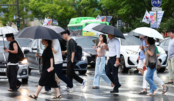 기상청은 16일 전국 체감온도가 35도 내외로 오를 것이라고 관측했다. 사진은 지난 14일 서울 종로구 세종대로에서 시민들이 비를 피해 퇴근하는 모습. /사진=뉴시스