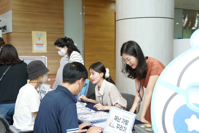 의학원 방문객, 환자들이 스티커북을 활용하여 직접 재난 가방 꾸리기 실습을 하고 있다./사진=동남권원자력의학원