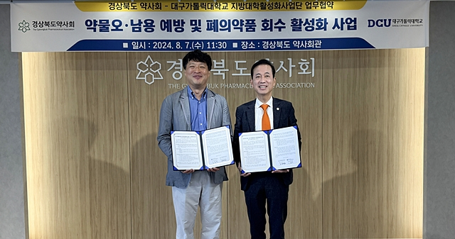 윤의철 대구가톨릭대 지방대학활성화사업단 부단장(왼쪽)과 고영일 경북도약사회장(오른쪽)이 업무협약을 체결한 뒤 기념촬영을 하고 있다./사진제공=대구가톨릭대학교