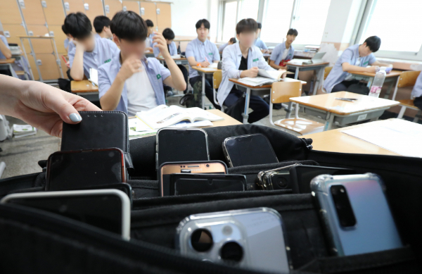 국가인권위원회가 휴대전화 소지 전면 금지가 자유를 침해한다는 이유로 중단하라 권고했으나 고등학교에서 이를 수용하지  않았다. 사진은 한 고등학교 교실에서 휴대폰을 수거하는 모습. /사진=뉴스1