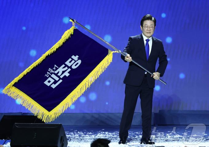 이재명 더불어민주당 대표가 18일 오후 서울 송파구 KSPO DOME(올림픽체조경기장)에서 열린 제1차 정기전국당원대회에서 당기를 흔들고 있다. 2024.8.18/뉴스1 ⓒ News1 김민지 기자