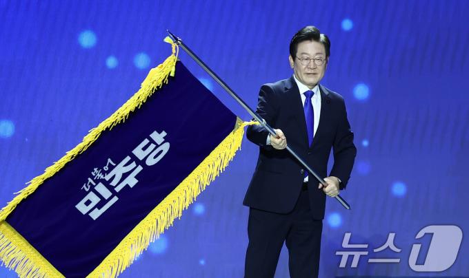 [사진] 당기 흔드는 이재명 대표 '연임 성공'