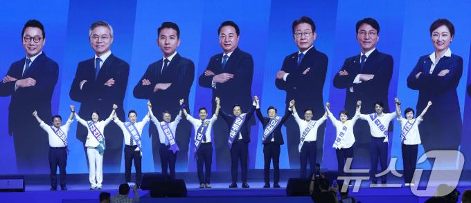 더불어민주당 김지수, 김두관, 이재명 대표 후보를 비롯한 최고위원 후보들이 18일 오후 서울 송파구 KSPO DOME(올림픽체조경기장)에서 열린 제1차 정기전국당원대회에서 손을 맞잡고아 당원들에게 인사하고 있다. 왼쪽부터 김병주, 강선우, 정봉주, 민형배 최고위원 후보, 김지수, 김두관, 이재명 당대표 후보, 김민석, 이언주, 한준호, 전현희 최고위원 후보. 2024.8.18/뉴스1 ⓒ News1 김민지 기자