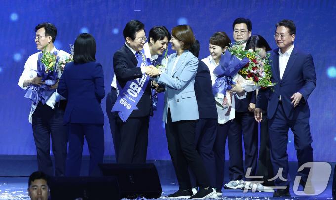 이재명 더불어민주당 대표를 비롯한 최고위원들이 18일 오후 서울 송파구 KSPO DOME(올림픽체조경기장)에서 열린 제1차 정기전국당원대회에서 고민정 최고위원 등 전임 최고위원들의 축하를 받고 있다. 2024.8.18/뉴스1 ⓒ News1 김민지 기자