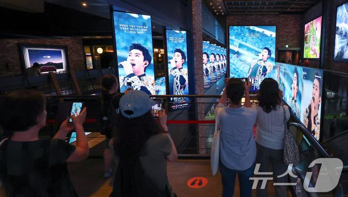 22일 오후 서울 CGV 용산아이파크몰을 찾은 시민들이 ‘임영웅│아임 히어로 더 스타디움’ 광고 영상을 스마트폰으로 촬영하고 있다. 2024.8.22/뉴스1 ⓒ News1 김진환 기자