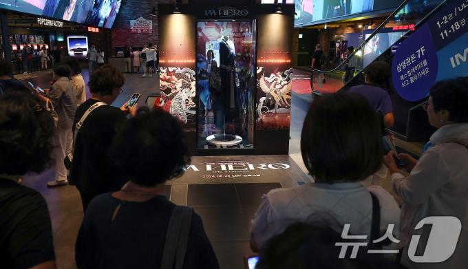 22일 오후 서울 CGV 용산아이파크몰에 마련된 ‘임영웅│아임 히어로 더 스타디움’ 무대 의상 전시 포토존에서 시민들이 사진을 찍고 있다. 2024.8.22/뉴스1 ⓒ News1 김진환 기자