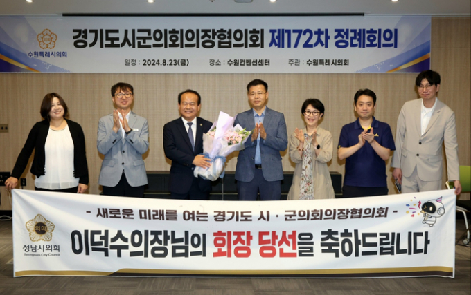 이덕수 성남시의회 의장(오른쪽으로부터 5번째)이 경기도시·군의장협의회 회장 취임식에서 관계자로부터 꽃다발을 받고 사진촬영을 하고 있다. / 사진제공=성남시의회