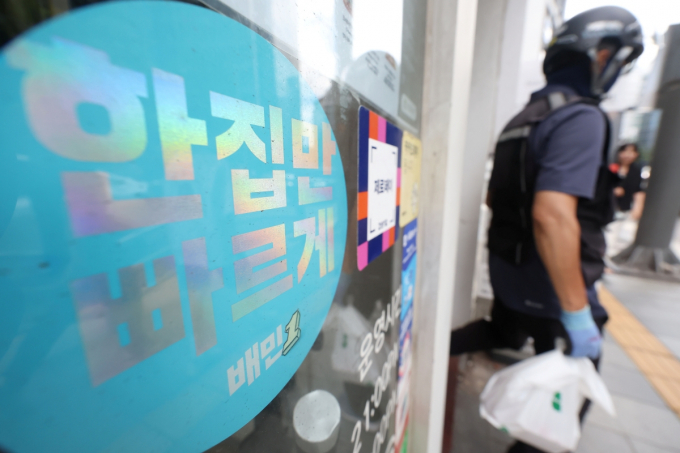지난 27일 오후 배달플랫폼·입점업체 상생협의체 제3차 회의가 개최됐다. 양측은 주문자 정보 공유에 대해 공감대를 형성하고 개선방안을 마련키로 했다. 서울 시내 한 카페에서 배달 기사가 주문한 음식을 들고 나서고 있다. /사진=뉴시스