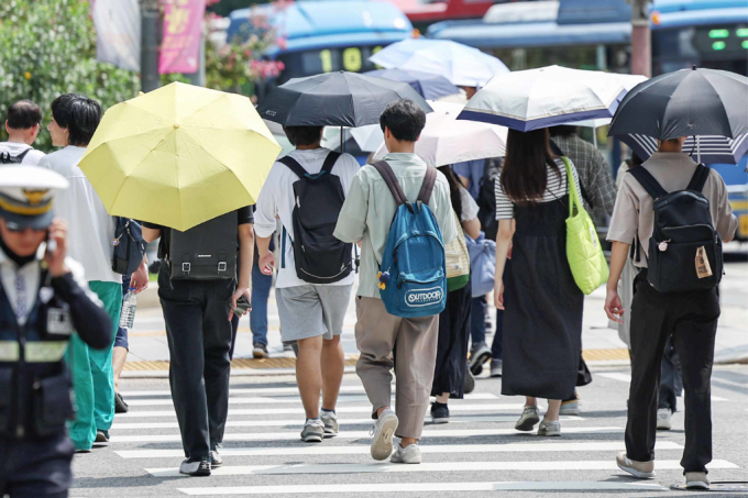  오는 29일은 당분간 무더위가 지속되는 가운데 강원영동과 경상권, 제주도는 비가 내릴 전망이다. 사진은 시민들이 양산을 펼쳐 들고 따가운 햇빛을 막고 있는 모습. /사진=뉴스1