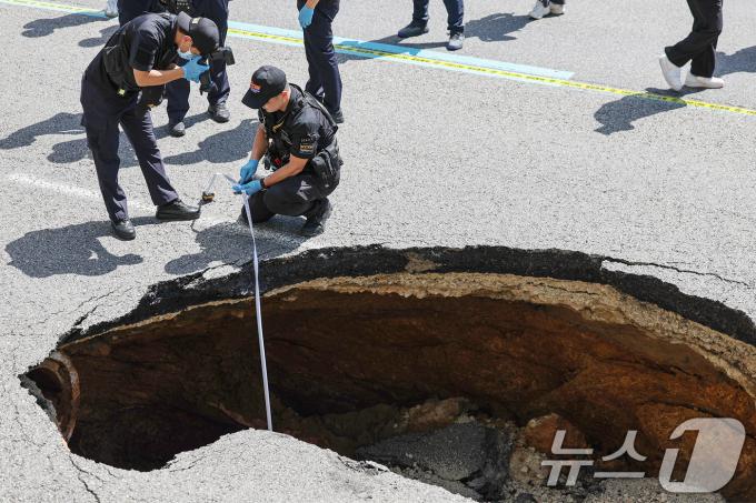 8월 29일 서울 서대문구 성산대교 방면 성산로에서 땅꺼짐 현상(싱크홀)이 발생해 경찰 과학수사대 대원들이 현장감식을 실시하고 있다. 소방당국 등에 따르면 이번 사고로 승용차에 탑승 중이던 70대 여성과 80대 남성이 중상을 입고 병원으로 옮겨졌다. 2024.8.29/뉴스1 ⓒ News1 민경석 기자