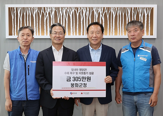 박현국 봉화군수(오른쪽 두번째)가 오도창 영양군수(오른쪽 세번째)에게 이웃돕기 성금 835만원을 전달하고 있다./사진제공=경북 영양군
