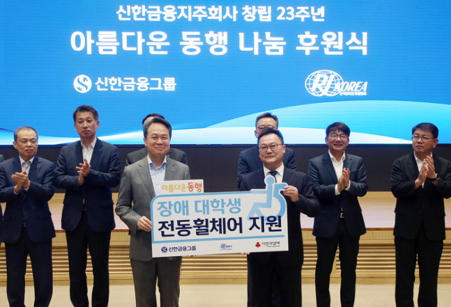 신한금융이 창립기념행사 비용을 절감해 장애가 있는 대학생들이 캠퍼스에서 안전하게 이동할 수 있도록 한국장애인재활협회를 통해 전동 휠체어를 지원했다. 2일 창립기념행사에서 진옥동 신한금융그룹 회장(맨앞줄 왼쪽)이 조성민 한국장애인재활협회 사무총장이 기념촬영을 하고 있다./사진=신한금융