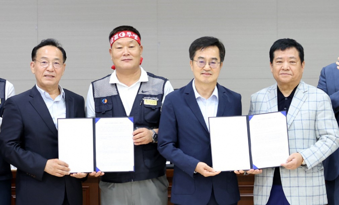4일 경기 수원시 경기지방노동위원회에서 경기도 버스 노사 관계자들이 합의문에 서명한 뒤 기념촬영을 하고 있다. 왼쪽부터 김태기 중앙노동위원회 위원장, 이기천 경기도버스노동조합협의회 의장, 김동연 경기도지사, 김기성 경기도버스운송사업조합 이사장. 사진제공=경기도 
