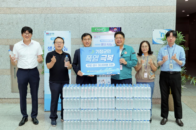 정재락 고리원자력본부 대외협력처장(왼쪽 세 번째)이 생수를 전달하고 김종천 기장군 안전도시국장(왼쪽 네 번째) 등과 기념 촬영을 하고 있다./사진=고리본부