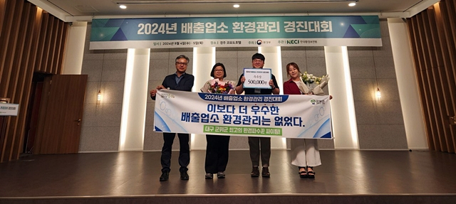 군위군 관계자들이 환경부가 주관하는 2024년도 배출업소 환경관리 실태평가에서 수상한 장관 표창장을 들어보이고 있다./사진제공=대구 군위군