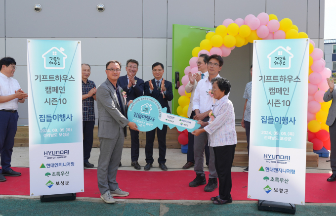 현대엔지니어링이 전남 보성군에서 '기프트하우스 캠페인 시즌10' 집들이 행사를 통해 주거취약계층에게 모듈러주택을 기증했다. 사진은 기증 행사에 참석했던 엄홍석(앞줄 왼쪽) 현대엔지니어링 커뮤니케이션 실장과 수혜자. /사진=현대엔지니어링