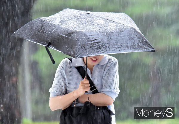 7일 전국이 대체로 흐린 가운데 오전과 밤사이 전국 대부분 지역에 소나기가 내릴 것으로 예보됐다. 사진은 지난 7월 장대비가 쏟아지는 2일 서울 송파구 올림픽로 일대에서 한 시민이 우산을 쓴 채 이동하는 모습. /사진=임한별 기자