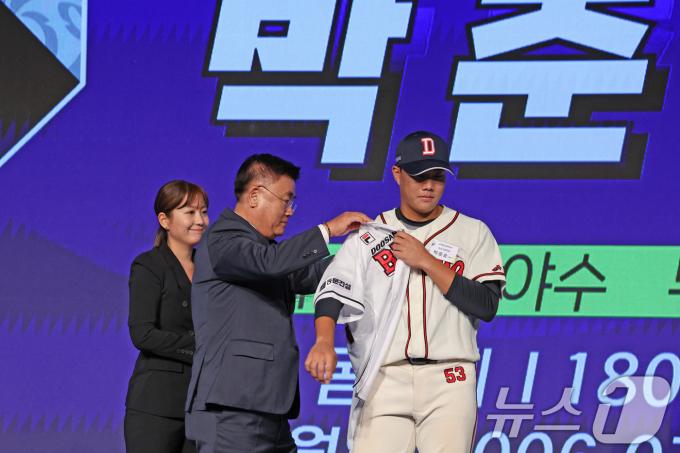 11일 오후 서울 송파구 롯데호텔 월드에서 열린 ‘2025 KBO 신인 드래프트’에서 두산 1라운드 6순위로 지명된 박준순(덕수고)이 두산 김태룡 단장으로부터 유니폼을 받고 있다. 2024.9.11/뉴스1 ⓒ News1 장수영 기자