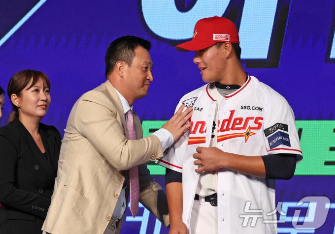 11일 오후 서울 송파구 롯데호텔 월드에서 열린 ‘2025 KBO 신인 드래프트’에서 SSG 1라운드 8순위로 지명된 이율예(강릉고)가 SSG 김재현 단장으로부터 유니폼을 받고 있다. 2024.9.11/뉴스1 ⓒ News1 장수영 기자