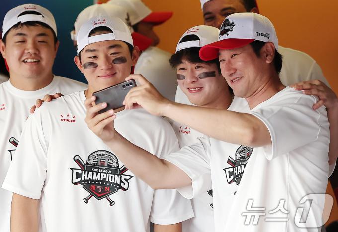 KIA 타이거즈 김도영(왼쪽부터), 박찬호, 이헌곤 코치가 17일 오후 인천시 미추홀구 문학동 SSG랜더스필드에서 열린 프로야구 '2024 신한 SOL 뱅크 KBO리그' KIA 타이거즈와 SSG 랜더스의 경기 종료 후 열린 정규리그 우승 행사를 앞두고 셀카를 찍고 있다. 2024.9.17/뉴스1 ⓒ News1 김진환 기자