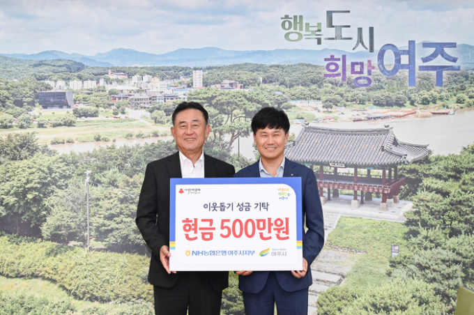 이문기 NH농협은행 여주시지부장(오른쪽)이 이충우 여주시장에게 이웃돕기 성금을 기탁한 뒤 기념촬영을 하고 있다. / 사진제공=여주시