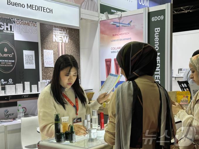 미하스(MIHAS) 박람회에서 말레이시아 방문객이 한국 화장품 부스에서 설명을 듣고 있다.