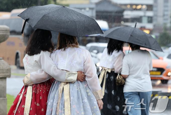 20일 오후 서울 종로구 경복궁을 찾은 외국인 관광객들이 우산을 함께 쓰고 이동하고 있다 2024.9.20/뉴스1 ⓒ News1 김진환 기자
