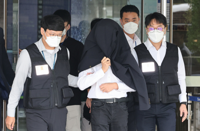 의료계 집단행동에 동참하지 않은 의사·의대생의 신상 정보가 담긴 블랙리스트 '감사한 의사'를 유포한 사직 전공의 정 모씨가 20일 서울 서초구 서울중앙지법에서 열린 구속 전 피의자 심문(영장실질심사)을 마친 뒤 경찰과 함께 이동하고 있다./사진=뉴스1 /사진=(서울=뉴스1) 장수영 기자
