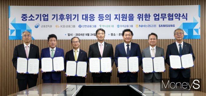 이복현 금융감독원장이 24일 서울 중구 은행회관에서 열린 중소기업 기후위기 대응 등의 지원을 위한 업무협약식에서 참석자들과 협약서를 들고 기념촬영을 하고 있다.  왼쪽부터 이석준 NH농협금융지주 회장, 함영주 하나금융지주 회장, 양종희 KB금융지주 회장, 이복현 금융감독원장, 한종희 삼성전자 부회장, 진옥동 신한금융지주 회장, 임종룡 우리금융지주 회장. /사진=공동 취재